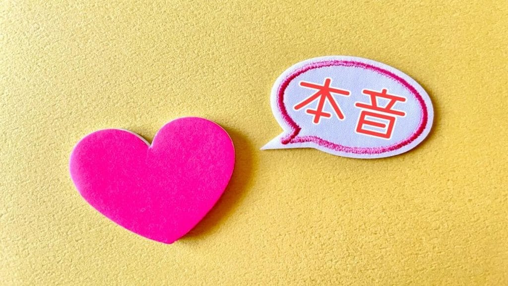 質感のある黄色地にピンクのハート型と吹き出し、赤い日本語の文字。